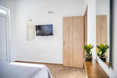 a bedroom with a bed and a tv on a wall at La mer stegna in Archangelos