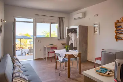 a living room with a couch and a table at La mer stegna in Archangelos