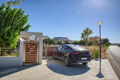 a black car parked in front of a garage at Paul’s Garden Luxury House in Haraki