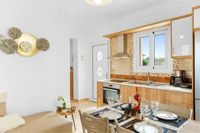 a kitchen with a table and a dining room at Paul’s Garden Luxury House in Haraki