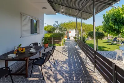 a patio with a table and chairs and a fence at Beachside Apartment-1 in Afantou