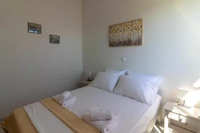 a bedroom with a white bed with towels on it at Beachside Apartment-1 in Afantou