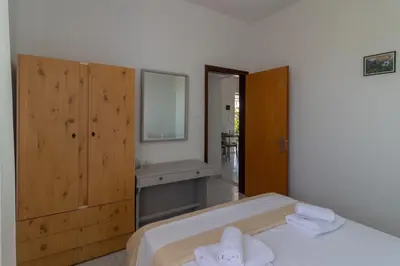 a bedroom with a bed and a sink and a mirror at Beachside Apartment-1 in Afantou
