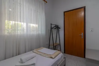 a bedroom with a bed and a wooden door at Beachside Apartment-1 in Afantou