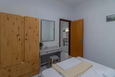 a bedroom with a bed and a sink and a mirror at Beachside Apartment-1 in Afantou