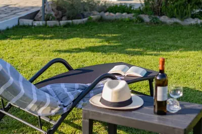 a picnic table with a hat and a bottle of wine at Beachside Apartment-1 in Afantou