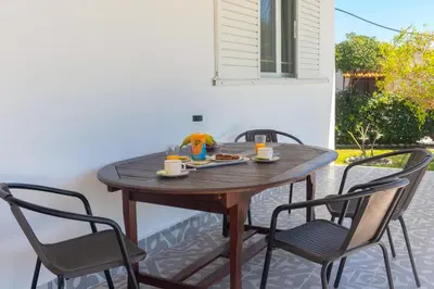 a wooden table with two chairs and a meal on it at Beachside Apartment-1 in Afantou