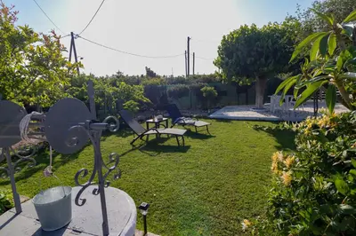 a garden with two benches and a table in the grass at Beachside Apartment-1 in Afantou