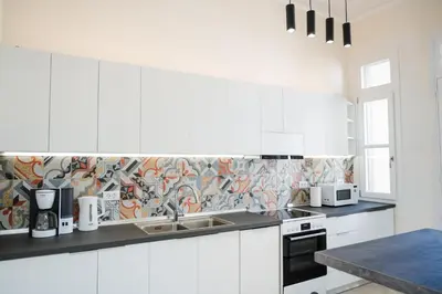 a white kitchen with white cabinets and a sink at Alcestis City Apartment in Rhodes Town