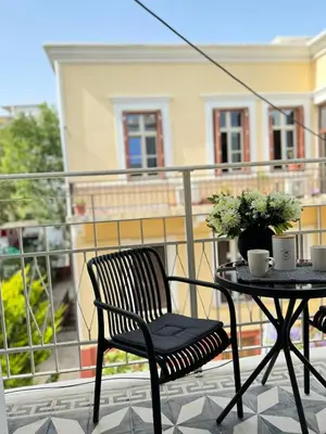 a black chair and a table on a balcony at Alcestis City Apartment in Rhodes Town