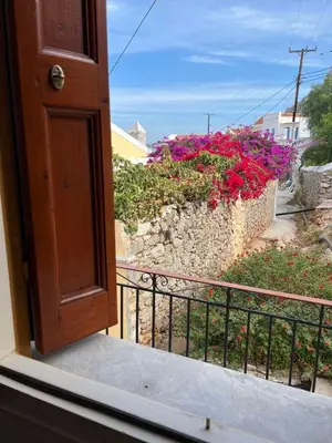 an open door to a balcony with flowers at Aeneo Studio 1 in Symi