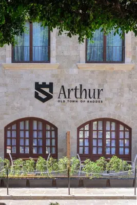 a sign on the side of a building with windows at Arthur Suites in Old Town in Rhodes Town