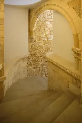 an archway in a stone building with stairs at Arthur Suites in Old Town in Rhodes Town