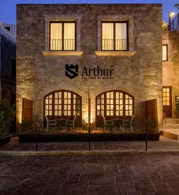 a building with a sign on the side of it at Arthur Suites in Old Town in Rhodes Town