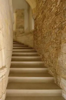 a staircase in a building with a stone wall at Arthur Suites in Old Town in Rhodes Town