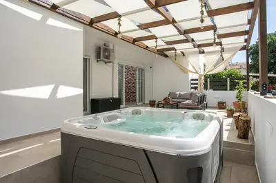 a hot tub on the patio of a house at La Vie Est Belle in Ixia