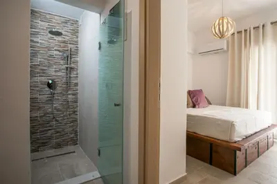 a bedroom with a glass shower and a bed at La Vie Est Belle in Ixia