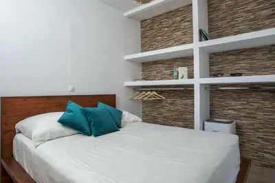 a bedroom with a white bed with blue pillows at La Vie Est Belle in Ixia