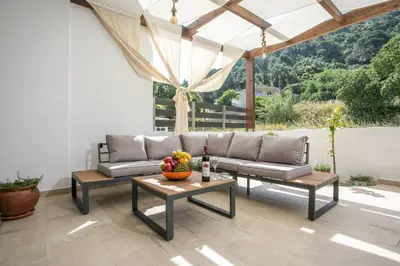 a patio with a couch and a table with fruit on it at La Vie Est Belle in Ixia