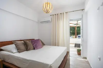 a bedroom with a bed and a large window at La Vie Est Belle in Ixia