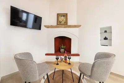 a room with a table with three chairs and a tv at M&K Traditional House in Theologos