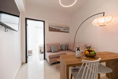 a living room with a table and a couch at Archangelos SKY Junior Apartment in Archangelos