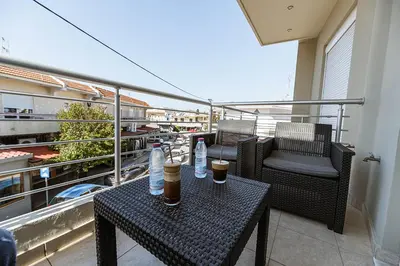 a balcony with two tables and chairs on a balcony at Archangelos SKY Junior Apartment in Archangelos