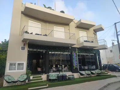 a building with chairs in front of it at Archangelos SKY Junior Apartment in Archangelos