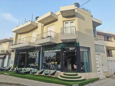 a large building with chairs in front of it at Archangelos SKY Junior Apartment in Archangelos
