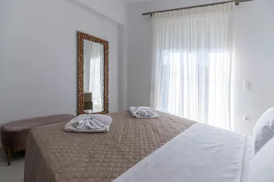 a bedroom with a large mirror and a bed at Archangelos SKY Junior Apartment in Archangelos