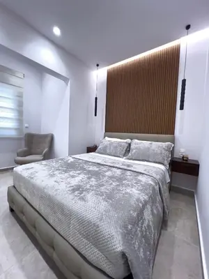 a bedroom with a large bed and a chair at AleNi City Apartment 2 in Rhodes Town