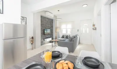 a kitchen and living room with a table with food at Casa di Hari in Afantou