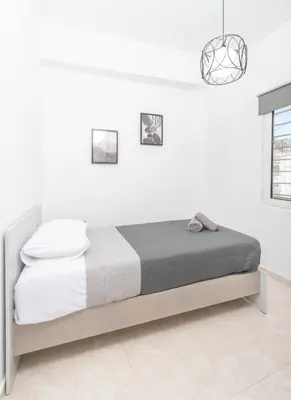 a white bedroom with a bed in a room at Casa di Hari in Afantou