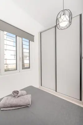a bedroom with windows and a bed with a towel at Casa di Hari in Afantou