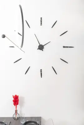 a clock on a wall next to a table at Casa di Hari in Afantou