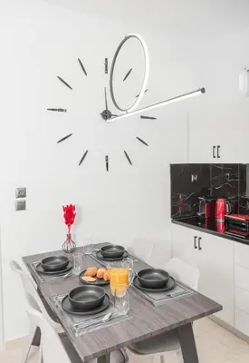 a kitchen with a table with black plates and orange juice at Casa di Hari in Afantou