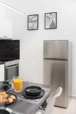 a kitchen with a table with plates of food and a refrigerator at Casa di Hari in Afantou