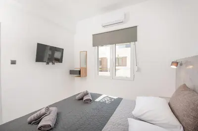 a bedroom with a bed and a tv on the wall at Casa di Hari in Afantou