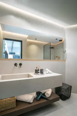 a bathroom with a sink and a large mirror at Karma Luxury Suites in Rhodes Town