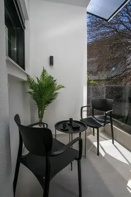 two chairs and a table and a potted plant on a balcony at Karma Luxury Suites in Rhodes Town