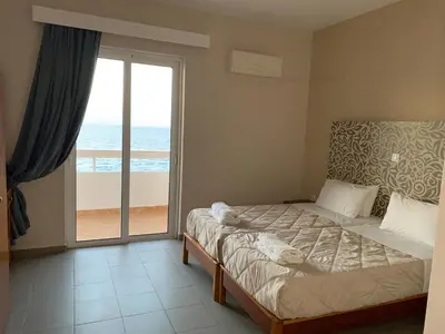 a bedroom with a bed with a view of the ocean at 4 Brothers in Rhodes Town