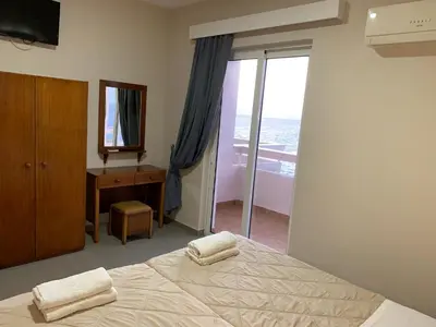 a bedroom with a bed and a dresser and a mirror at 4 Brothers in Rhodes Town