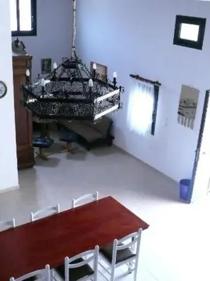 a dining room with a table and a chandelier at Villa Rosa in Kattavía