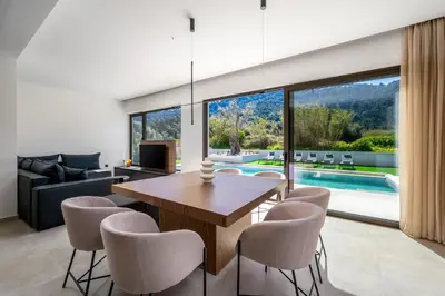 a dining room with a table and chairs and a pool at Casa Yiava in Ialyssos