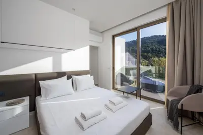 a bedroom with a white bed and a large window at Casa Yiava in Ialyssos