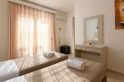a hotel room with two beds and a mirror at Next to Haraki beach , taverns bars & 10 to Lindos in Haraki
