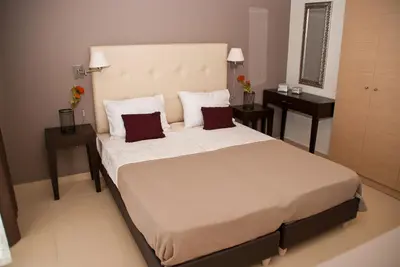 a bedroom with a large bed with two tables at Next to Haraki beach , taverns bars & 10 to Lindos in Haraki