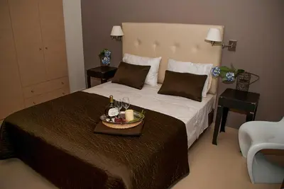 a bedroom with a large bed with a tray with drinks on it at Next to Haraki beach , taverns bars & 10 to Lindos in Haraki