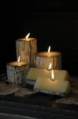 three candles sitting on top of wooden logs at Next to Haraki beach , taverns bars & 10 to Lindos in Haraki