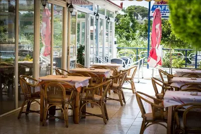 a row of tables and chairs in a restaurant at Aphrodite Apartments in Kallithea Rhodes